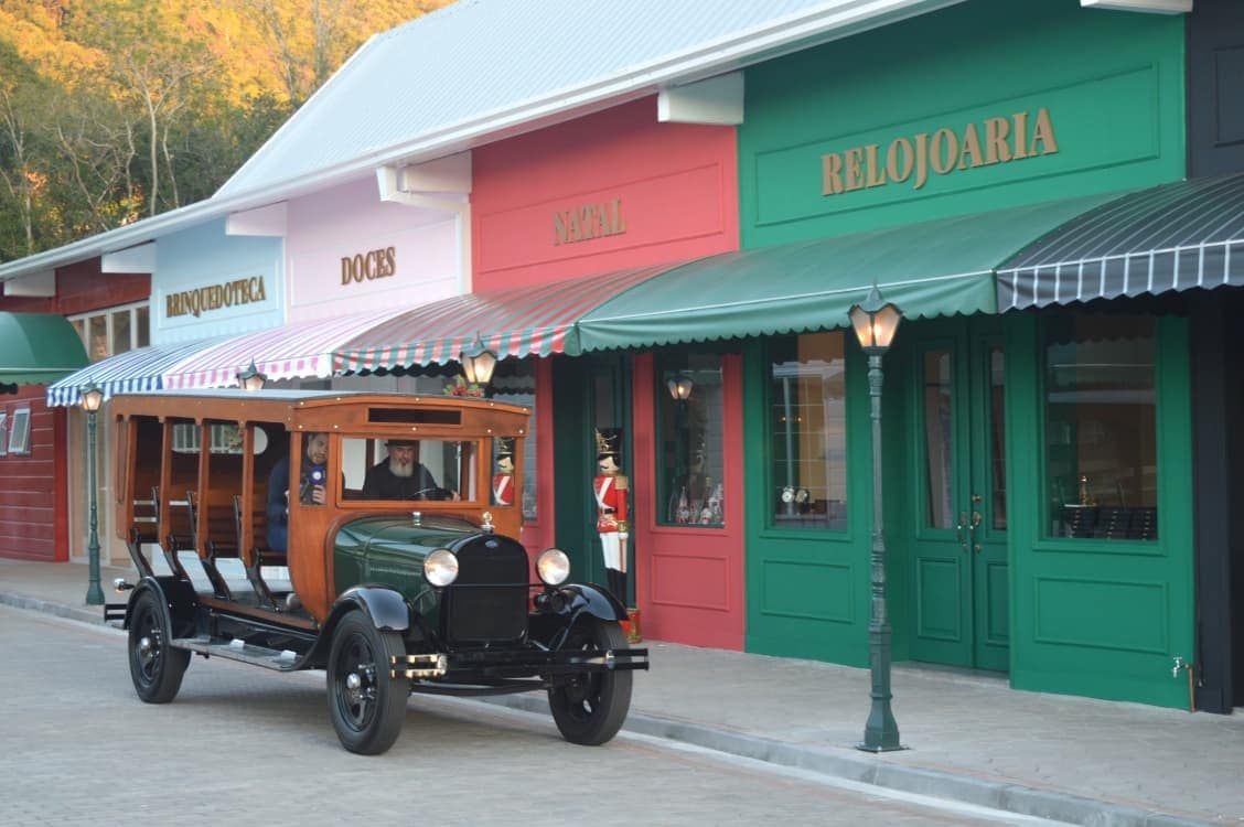 Jardineira Ford antiga em frente às lojas coloridas do Model A Village em Nova Petrópolis