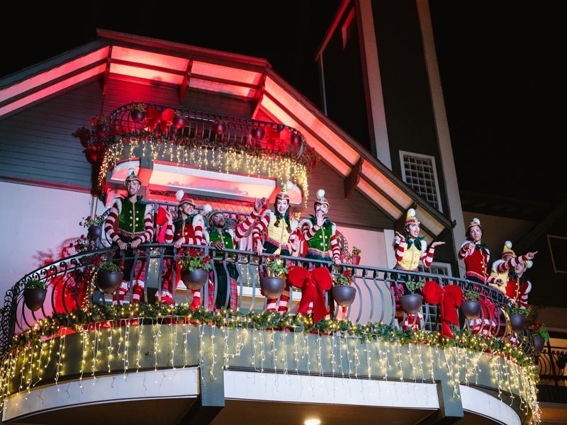Elenco de personagens natalinos na sacada iluminada durante o Bustour Illumination Show em Gramado