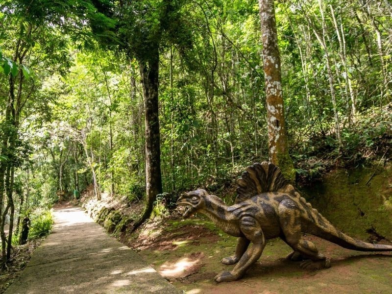 Escultura de dinossauro na trilha do Jardim Jurássico do Jardim dos Pinhais