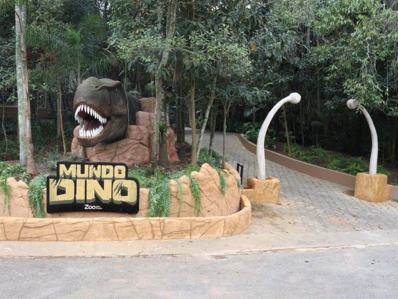 Entrada temática do Mundo Dino com réplica de dinossauro em São Paulo
