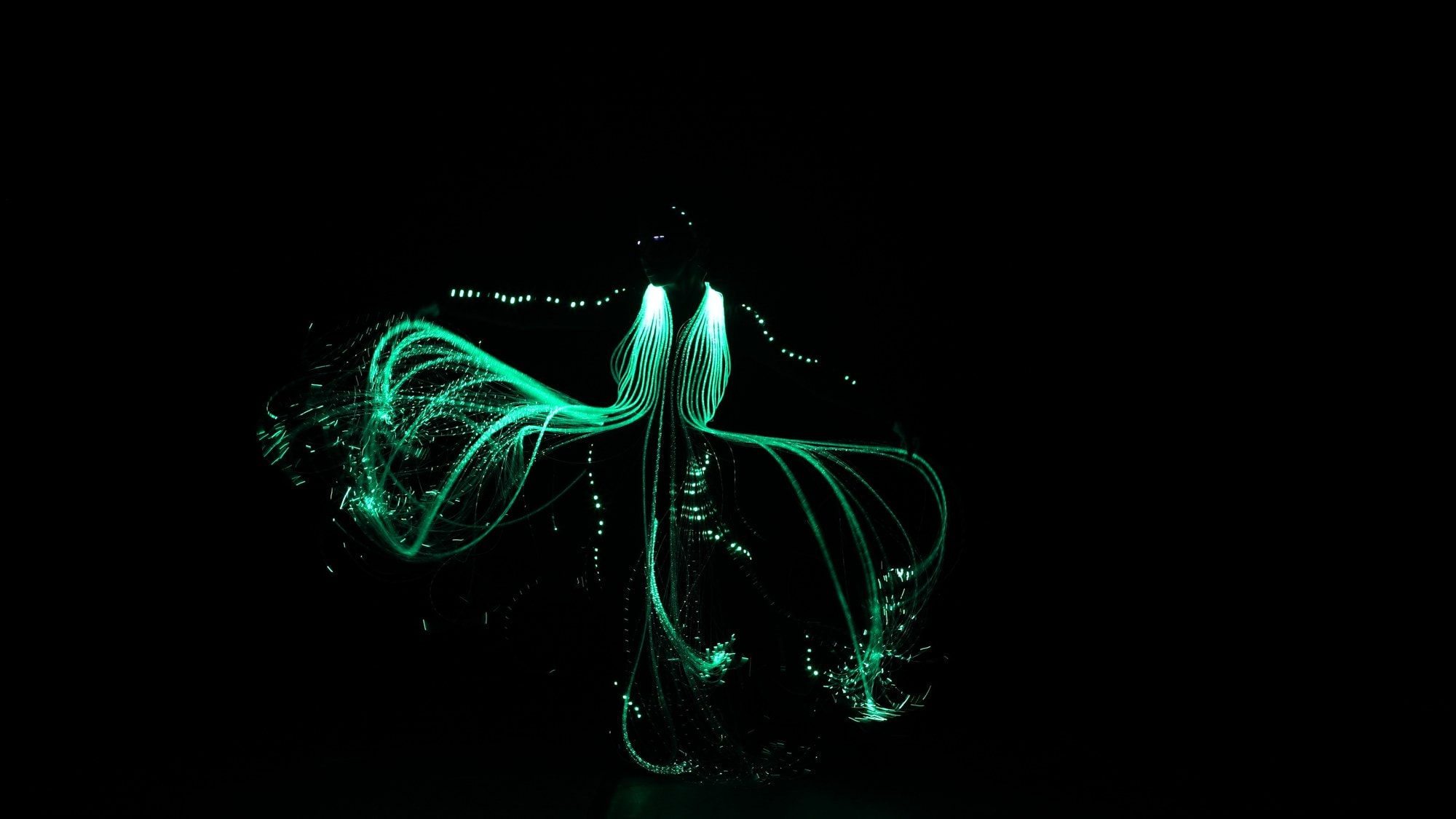 Figurino de fibra ótica verde em movimento no espetáculo O Brilho do Natal, Natal Luz Gramado 2026