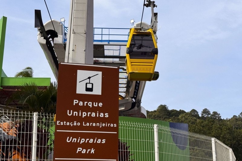 Placa da Estação Laranjeiras do Parque Unipraias com bondinho ao fundo