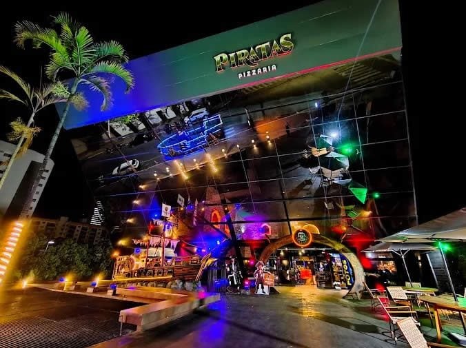 Fachada da Piratas Pizzaria à noite, com o navio pirata na entrada, em Caldas Novas-GO