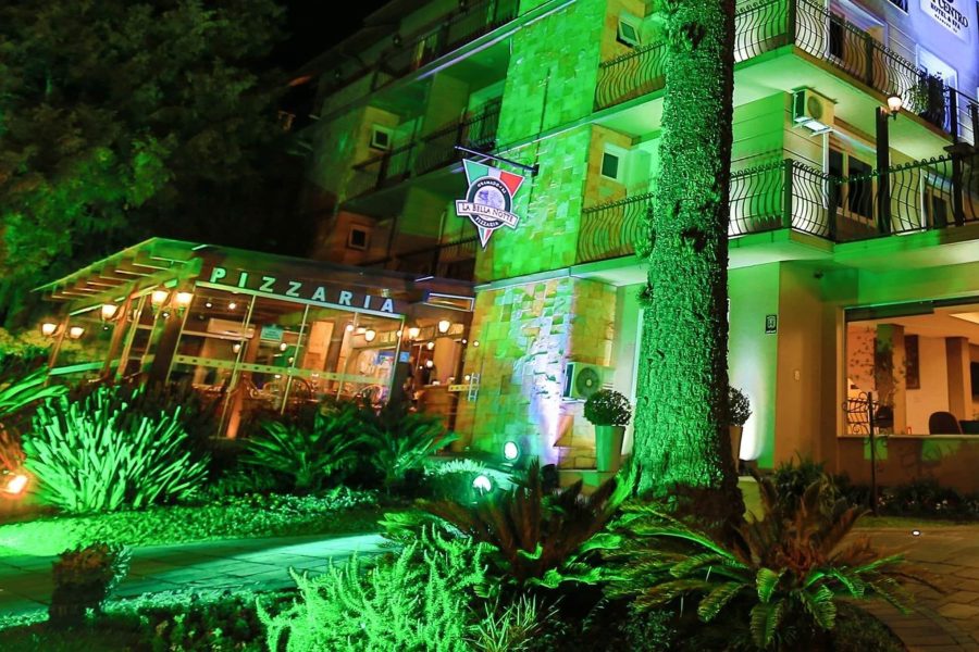 Fachada iluminada da La Bella Notte Pizzaria, junto ao Sky Centro Hotel, no centro de Gramado
