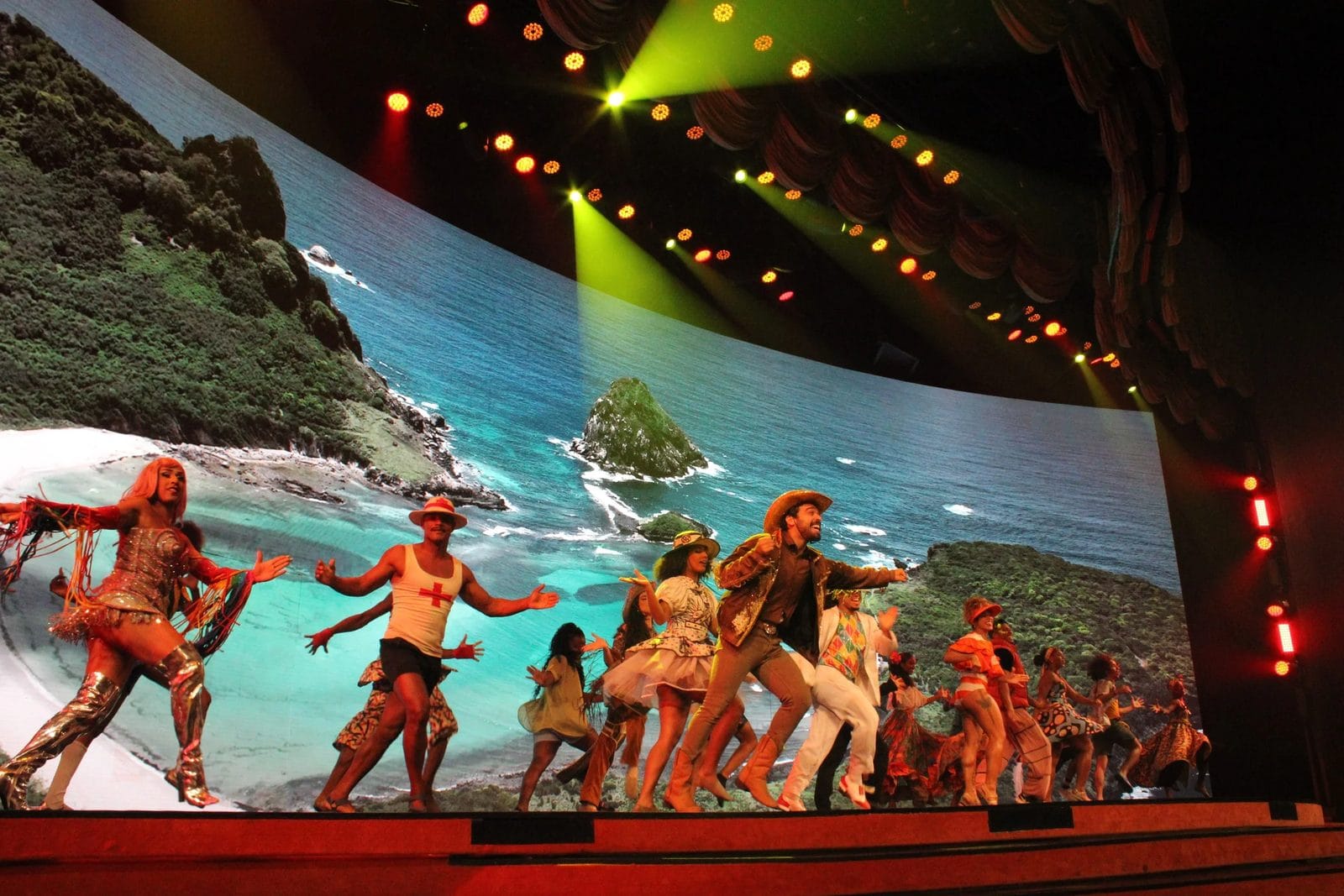 Bailarinos com cenário de praia no painel de LED 4D do Roxy Dinner Show, em Copacabana