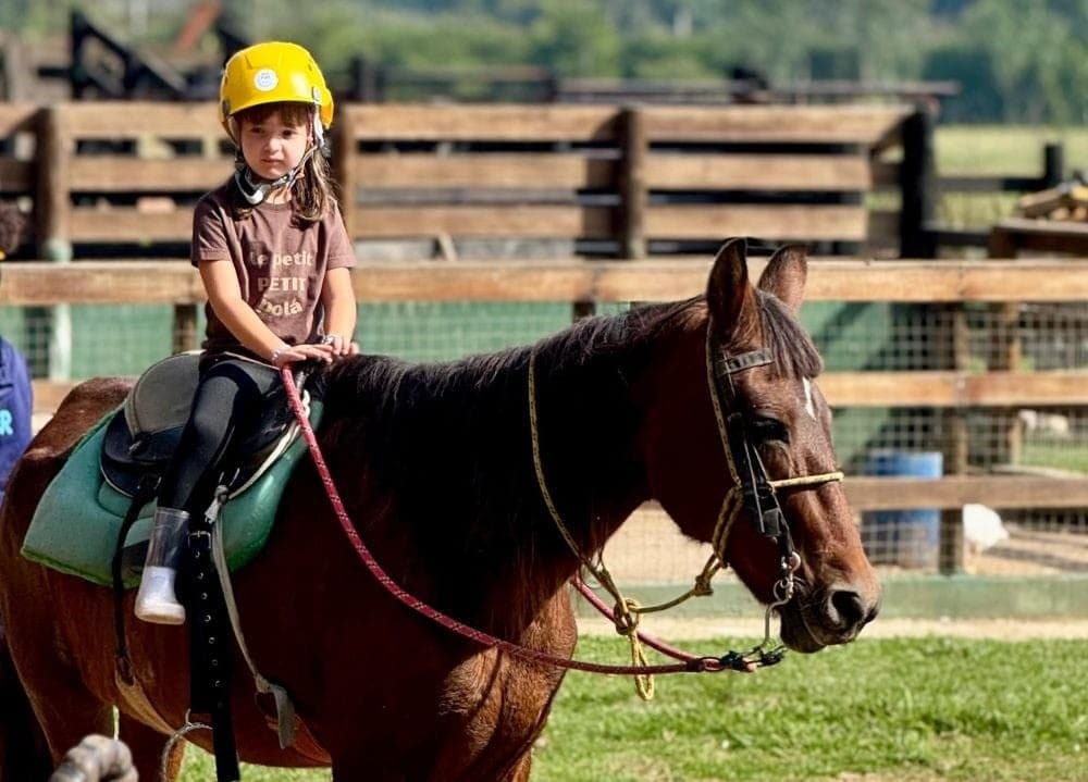 Criança com capacete no passeio a cavalo do Sítio Castelinho Hotel Fazenda em Cesário Lange