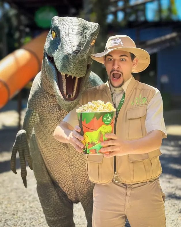 Guia da Vila Encantada com o Dino Raptor e balde de pipoca da Vila do Café, em Pomerode-SC