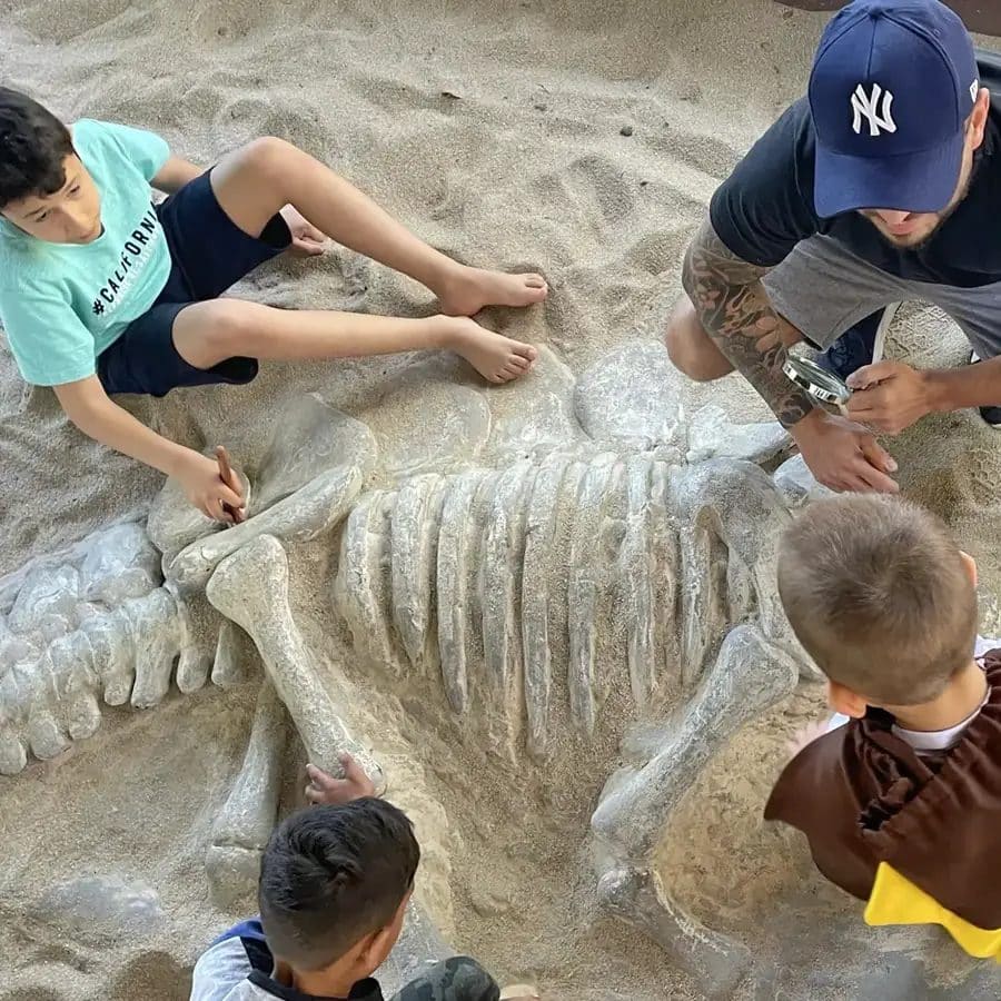 Crianças escavando esqueleto de dinossauro na Vila do Paleontólogo, na Vila Encantada em Pomerode-SC