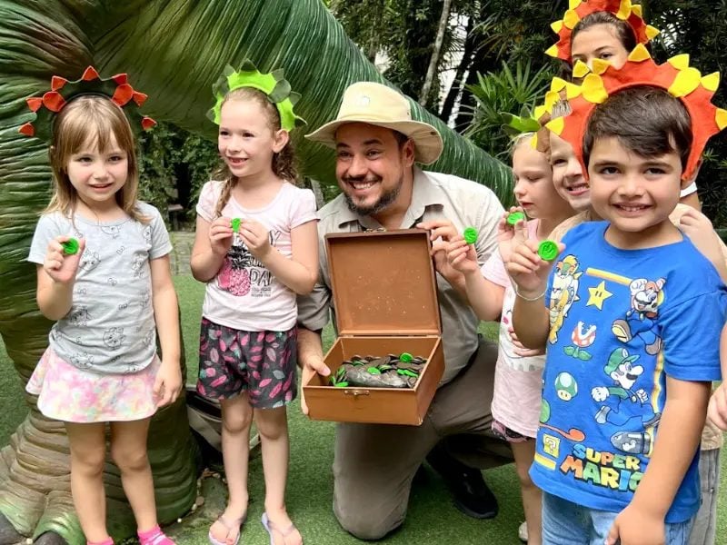 Crianças com o guia paleontólogo mostrando o baú de fósseis na Vila Encantada, em Pomerode-SC