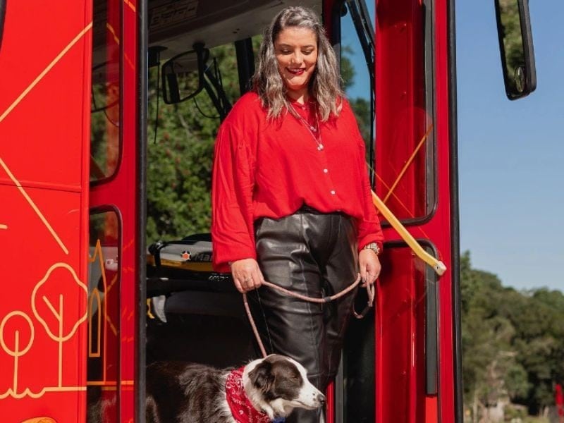 Passageira descendo do Bustour com seu cachorro em uma das paradas