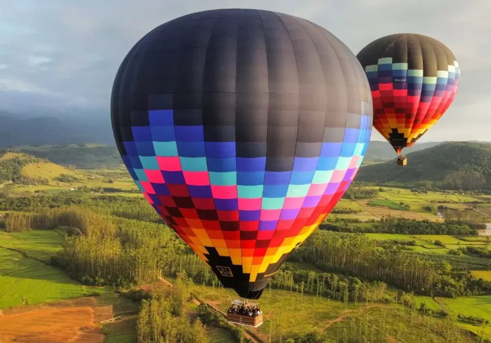 Dois balões coloridos sobrevoando campos e morros no voo da Canyons e Balões em Praia Grande-SC