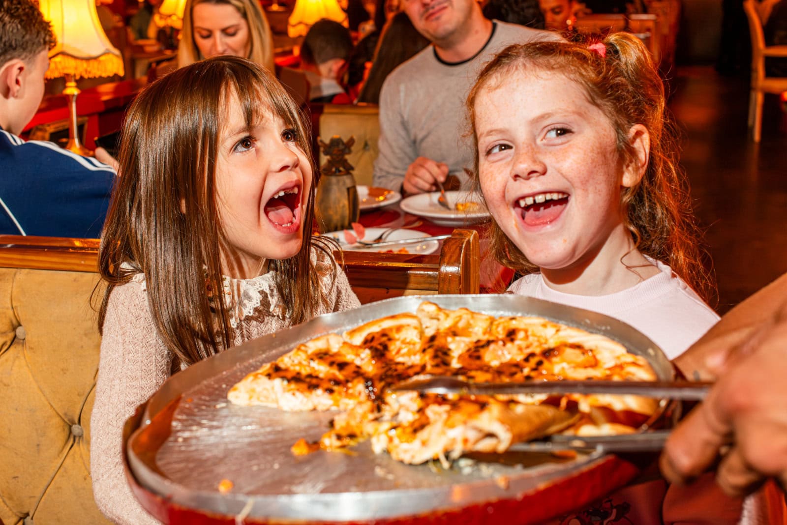 Crianças se divertindo com pizza no jantar pirata da Cara de Mau em Gramado