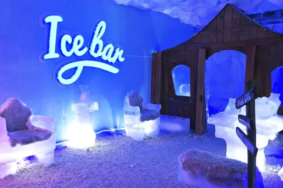 Ice Bar Mundo Gelado em Canela com letreiro neon, poltronas e casinha esculpidas em gelo