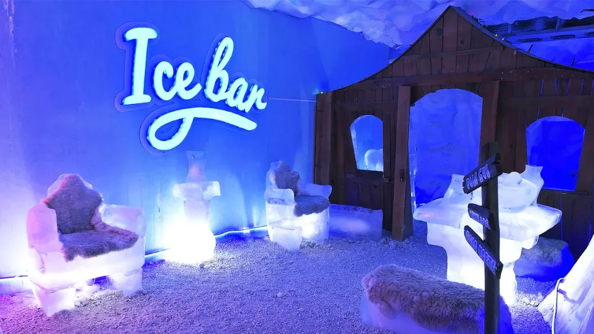 Ice Bar Mundo Gelado em Canela com letreiro neon, poltronas e casinha esculpidas em gelo