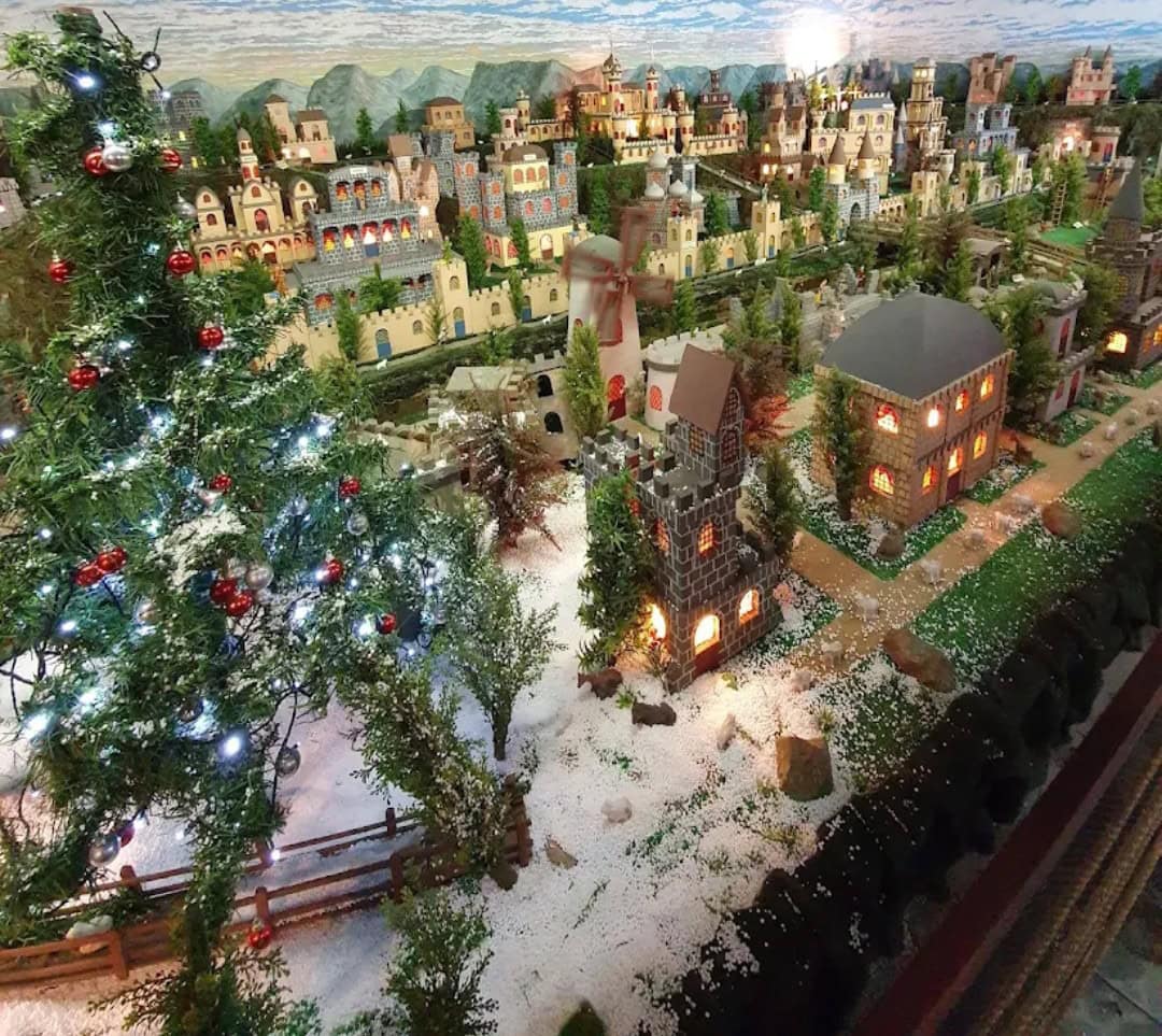 Vila natalina em miniatura com castelos e árvore decorada no Mundo Encantado em Gramado