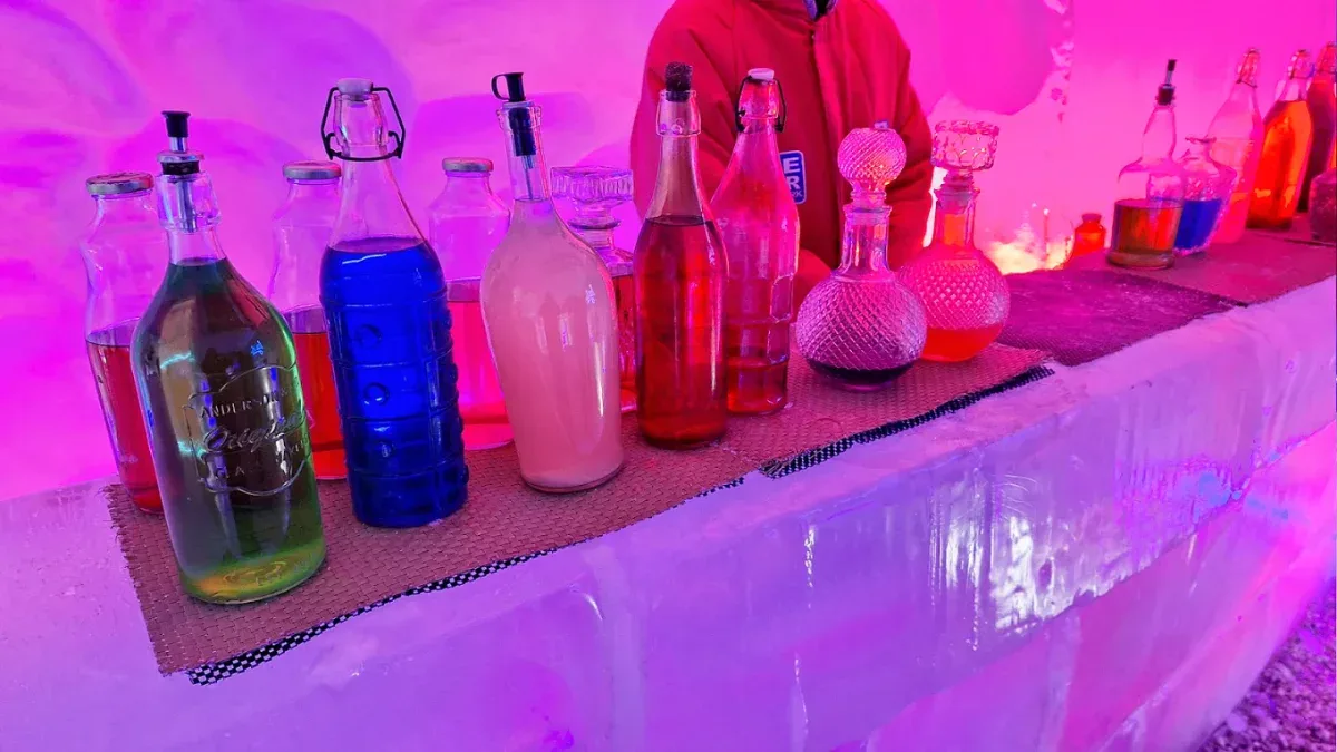 Balcão de gelo com garrafas de drinks coloridos no Ice Bar Mundo Gelado em Canela