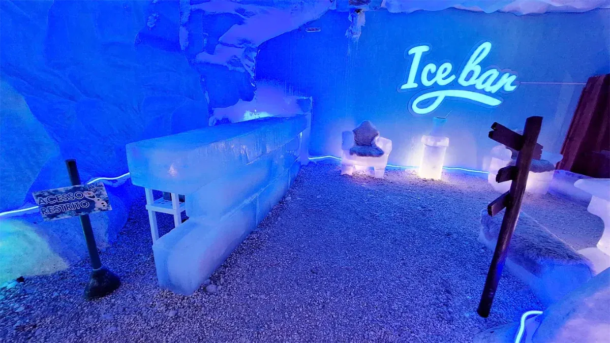 Câmara fria do Ice Bar Mundo Gelado em Canela com letreiro neon e banco de gelo