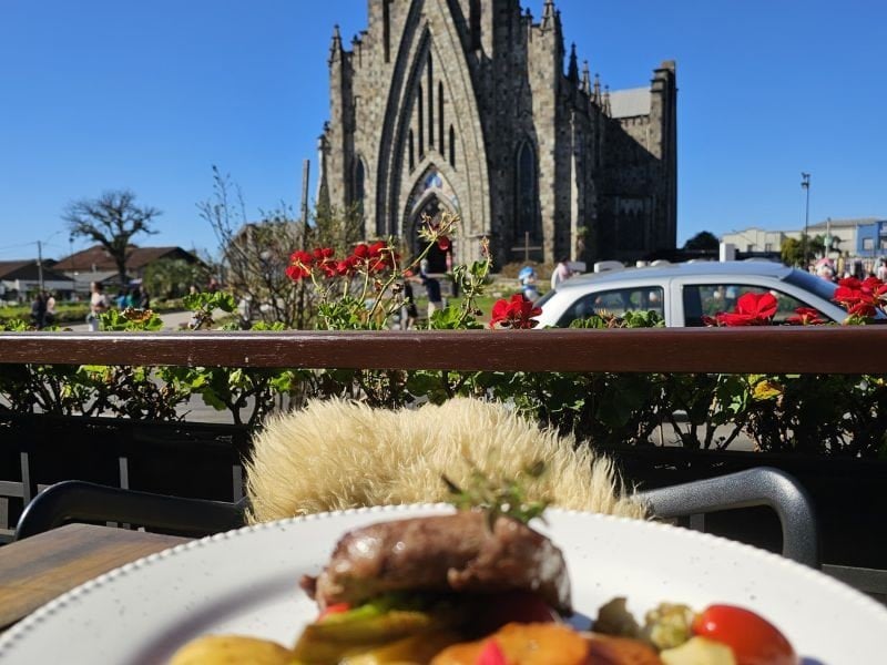 Mesa externa do Otto Bistrot com vista para a Catedral de Pedra em Canela