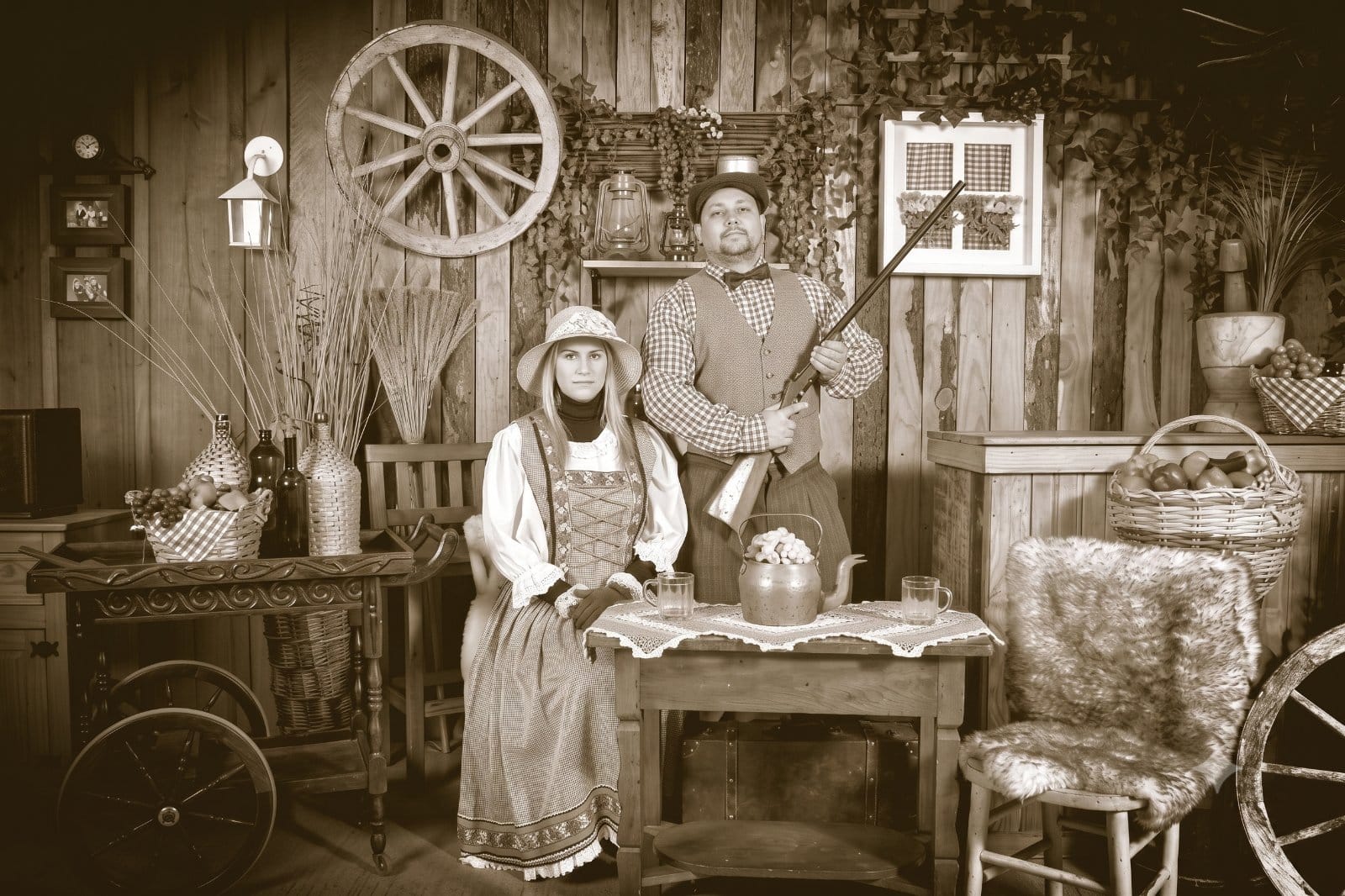 Casal de colonos com trajes de época em cenário rústico na Recordar Fotos em Canela