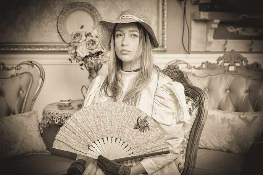 Mulher com vestido, chapéu e leque de época em foto antiga na Recordar Fotos em Gramado – cupom OVIAJANTE com 5% de desconto