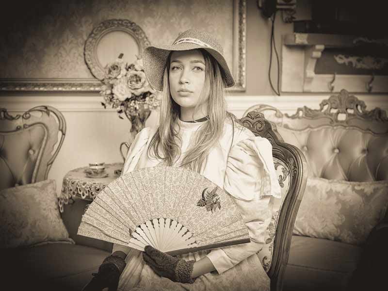 Mulher com vestido, chapéu e leque de época em foto antiga na Recordar Fotos em Gramado – cupom OVIAJANTE com 5% de desconto