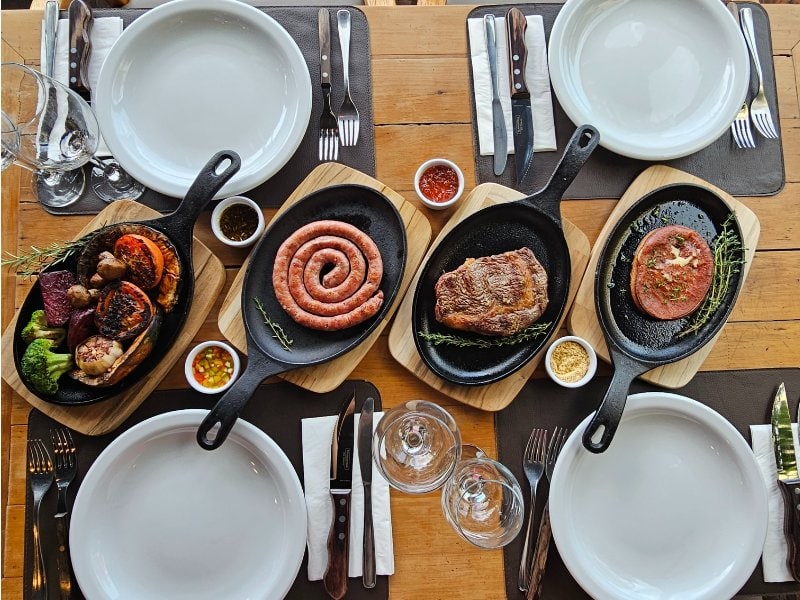 Mesa posta com carnes nobres na brasa no Sello Restaurante em Canela