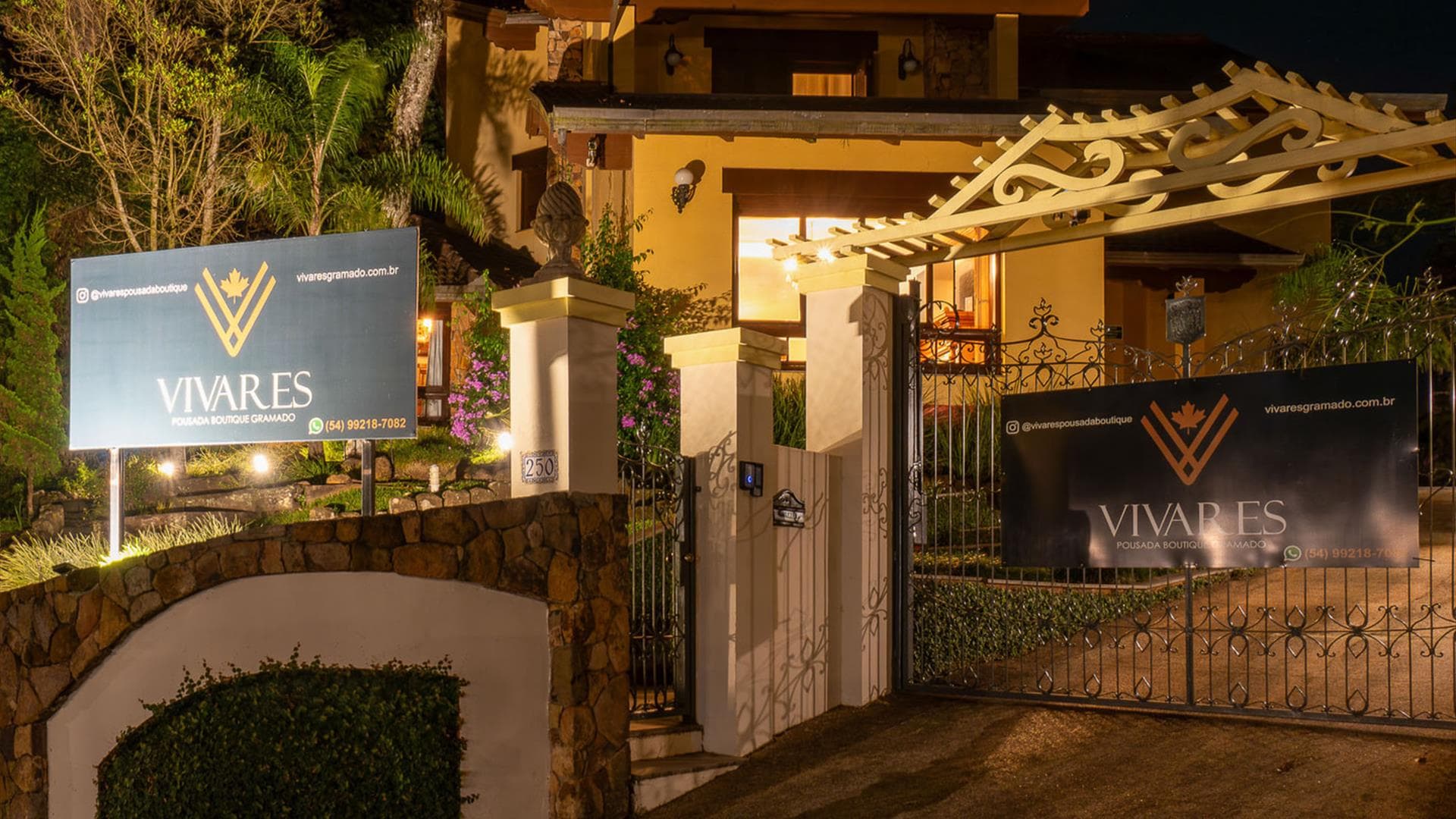 Portão iluminado à noite da Vivares Pousada Boutique Gramado, no Centro de Gramado