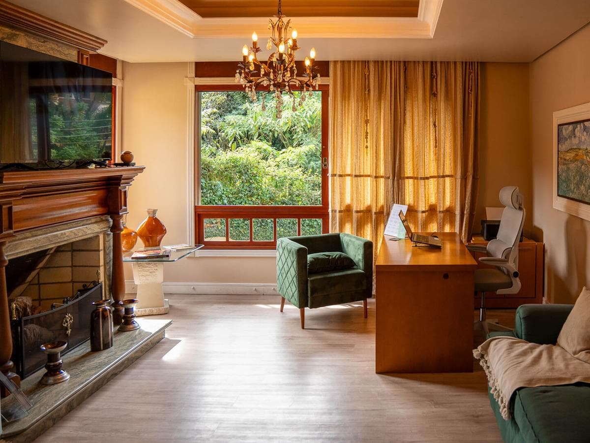 Sala com lareira e poltronas da Vivares Pousada Boutique Gramado, pousada boutique no Centro de Gramado