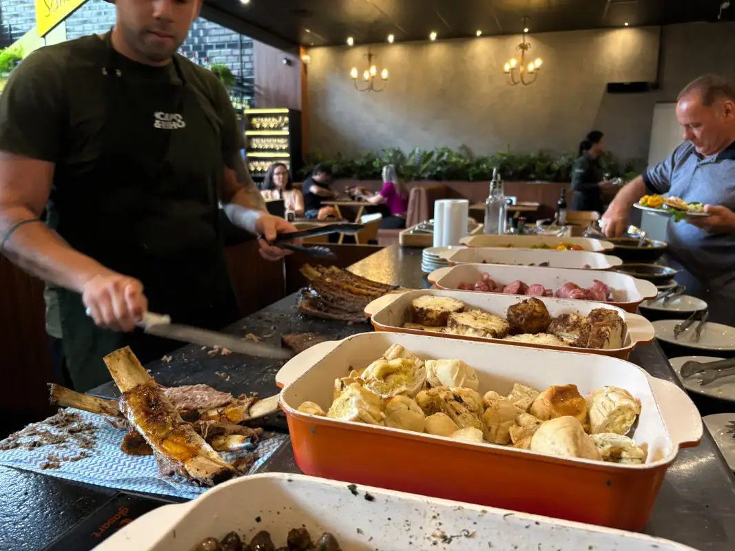 Churrasqueiro corta costela no buffet do Campo & Vinho, em Gramado