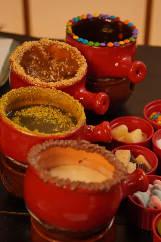 Fondues de chocolate com pistache, doce de leite e confeitos da sequência Premium do Caquelon, em Canela