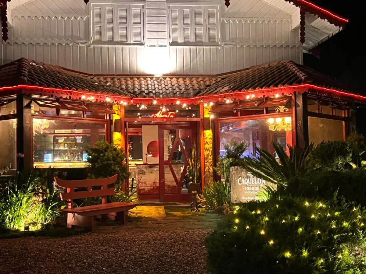 Fachada iluminada do Caquelon Fondue à noite, na Quinta da Serra, em Canela-RS