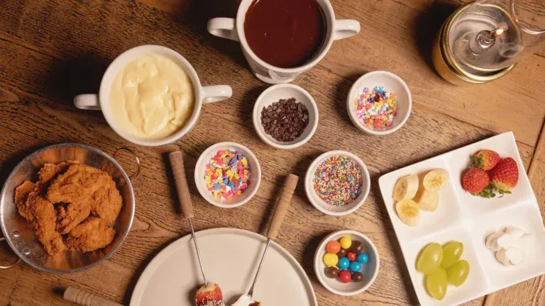 Fondue de chocolate branco e ao leite com frutas e confeitos na mesa do Chalezinho, em Gramado