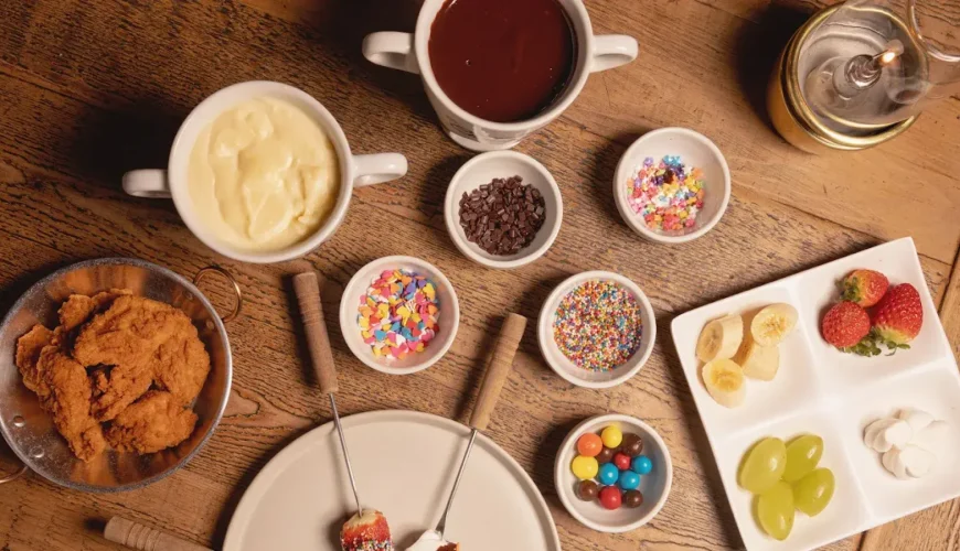 Fondue de chocolate branco e ao leite com frutas e confeitos na mesa do Chalezinho, em Gramado