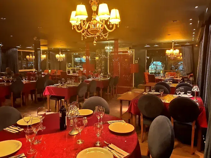 Salão do Restaurante Chaplin's com toalhas vermelhas e lustres, em Gramado