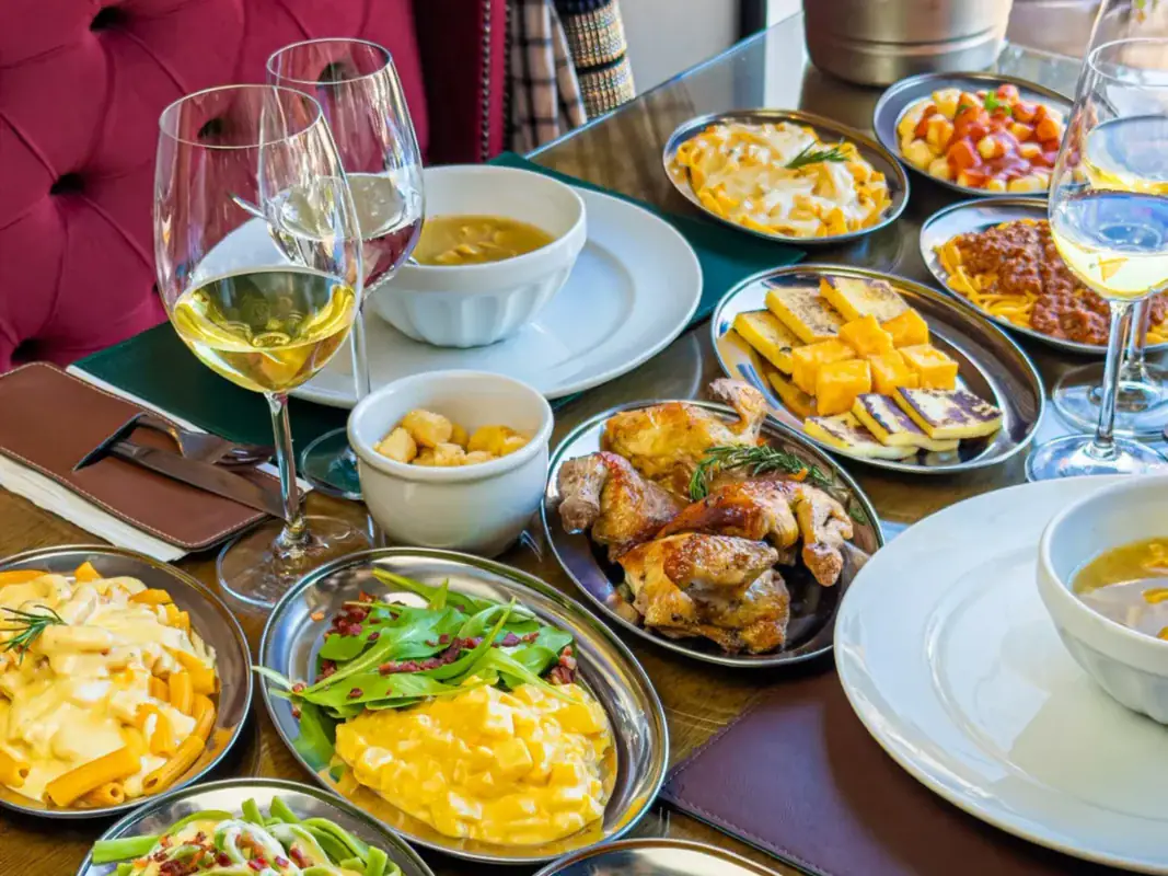 Mesa posta com a sequência de galeto, massas, polenta e saladas do Madia Cucina Gramado
