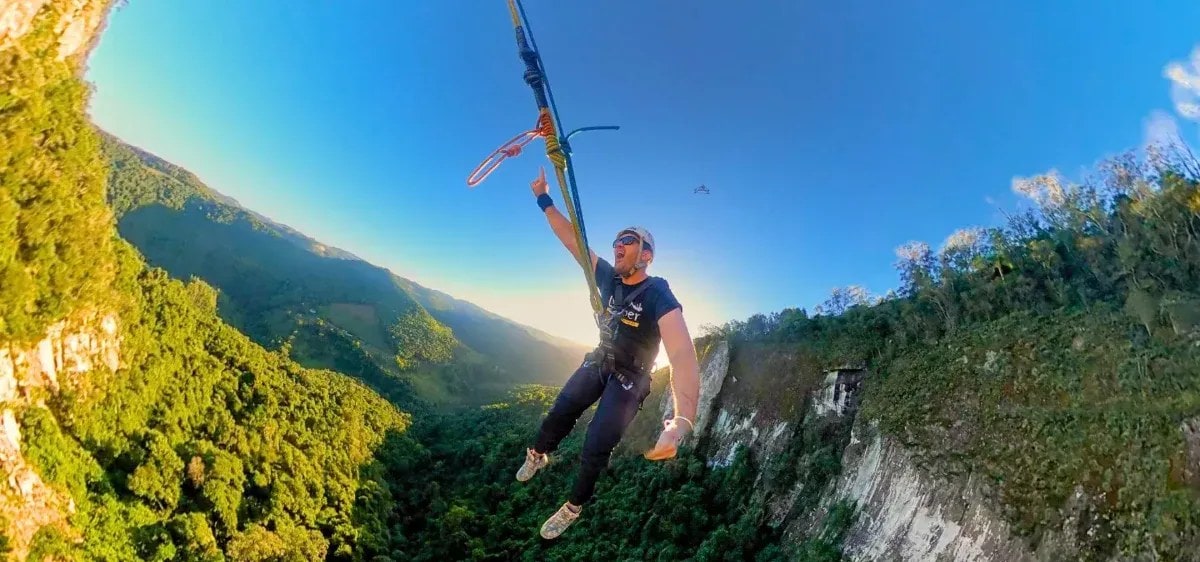 Aventureiro suspenso por cordas junto ao paredão da Eulália, no Parque Gasper, em Bento Gonçalves