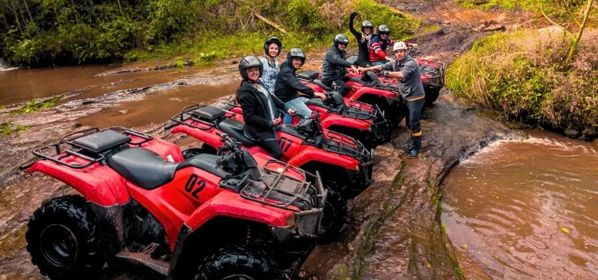 Grupo na trilha de quadriciclo do Parque Gasper, atravessando um riacho em Bento Gonçalves