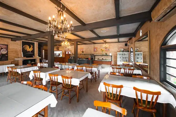 Salão do restaurante Reino da Boêmia, em Gramado, com mesas e cadeiras de madeira em ambiente de castelo